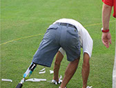 Jugador de golf amputado:Jugador de golf amputado de una pierna, con una prótesis ortopédica.  