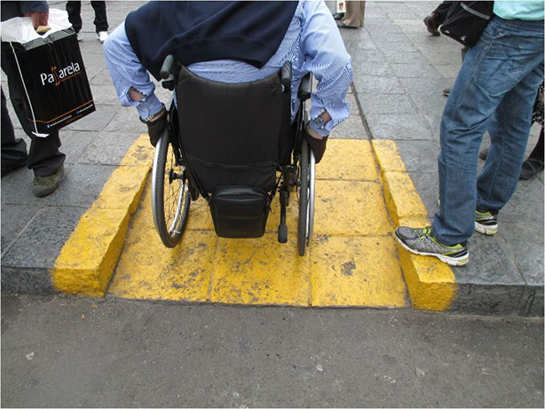 Acceso accesible por rampa-vado. Señalización excesiva en la rampa. 